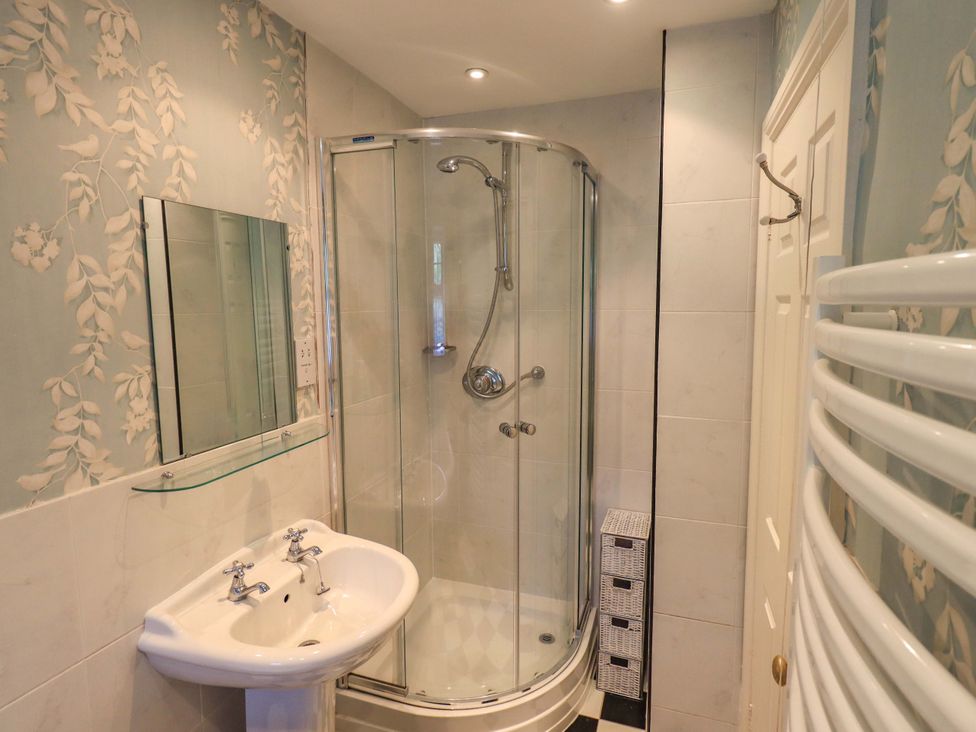 A bathroom with shower and sink at Stoker’s Cottage, Windermere