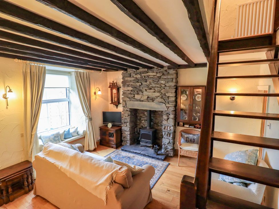 A living room with a fireplace and television at Stoker’s Cottage Bowness-On-Windermere