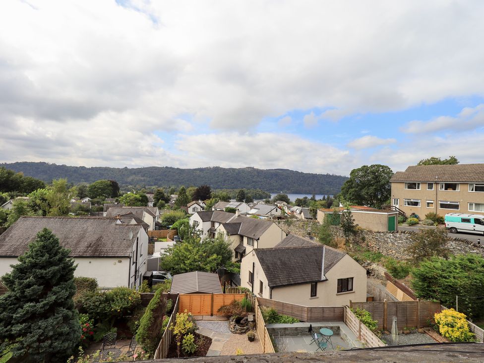 A view of houses and trees towards a lake and mountains at Stoker’s Cottage Bowness-On-Windermere