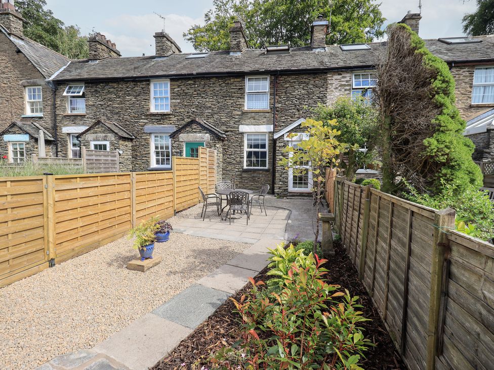 A garden with a table and chairs in Stoker’s Cottage in Bowness-On-Windermere
