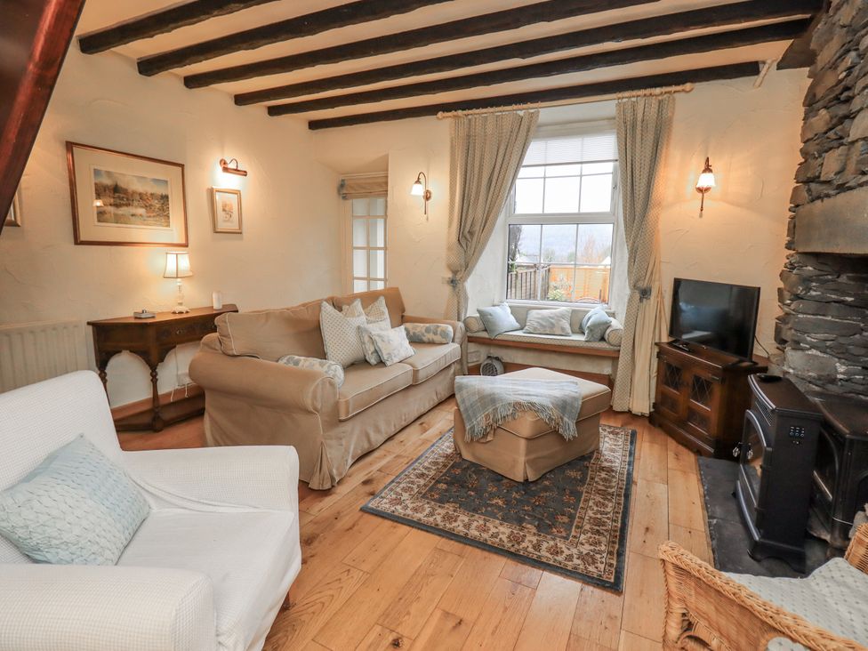 A living room with a sofa and television at Stoker’s Cottage in Bowness-On-Windermere