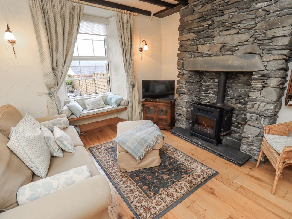 A living room with a sofa and fireplace at Stoker’s Cottage in Bowness-On-Windermere