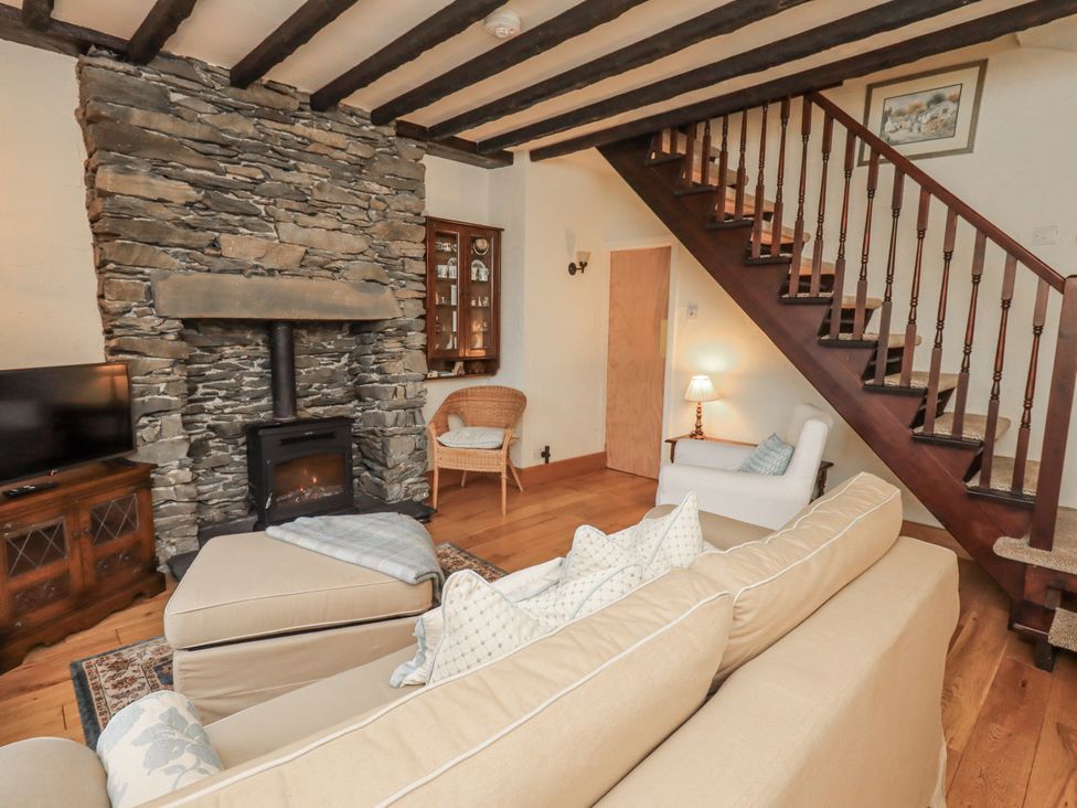 A living room with a sofa and fireplace at Stoker’s Cottage in Bowness-On-Windermere