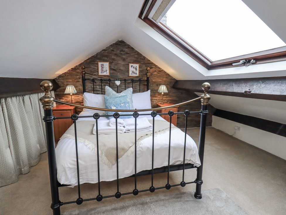 A bedroom with a bed and bedside lamps at Stoker’s Cottage in Bowness-On-Windermere