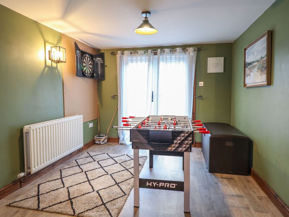 A game room with a foosball table and dartboard at Idris Barn in Dolgellau