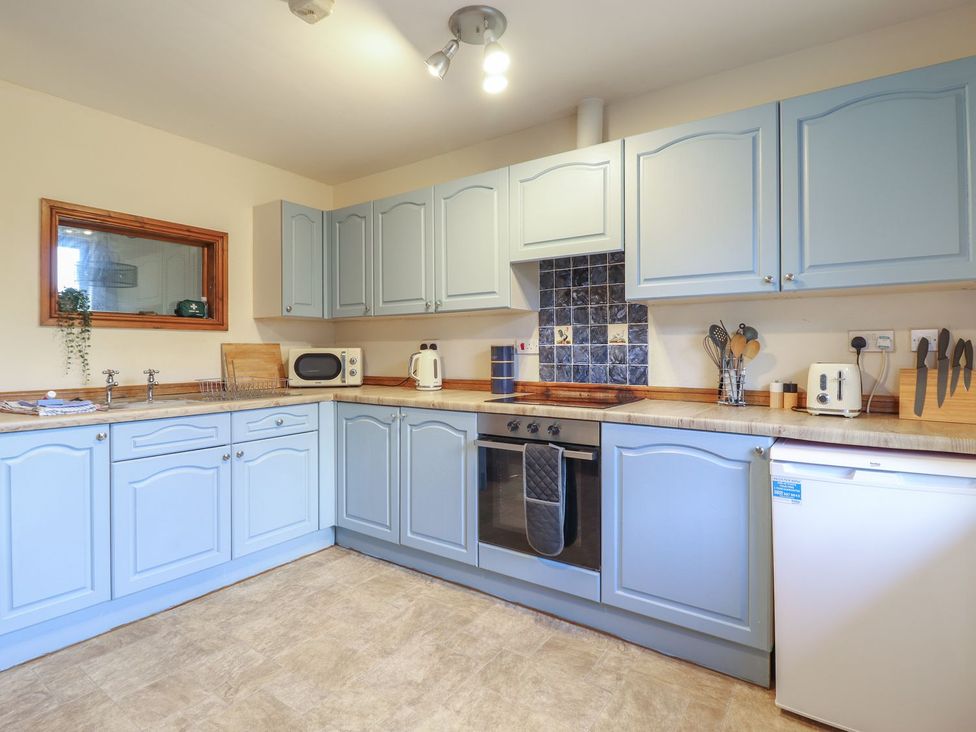 A kitchen with cabinets and appliances at Idris Barn Dolgellau