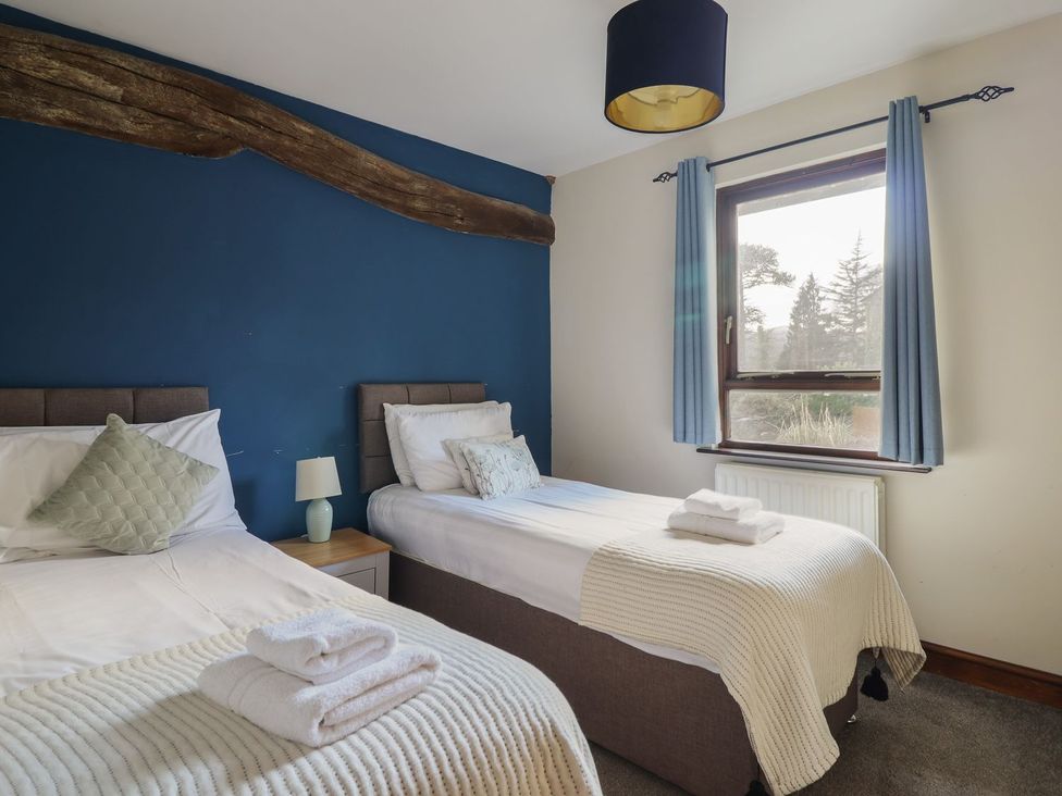 A bedroom with two beds and a window at Idris Barn in Dolgellau