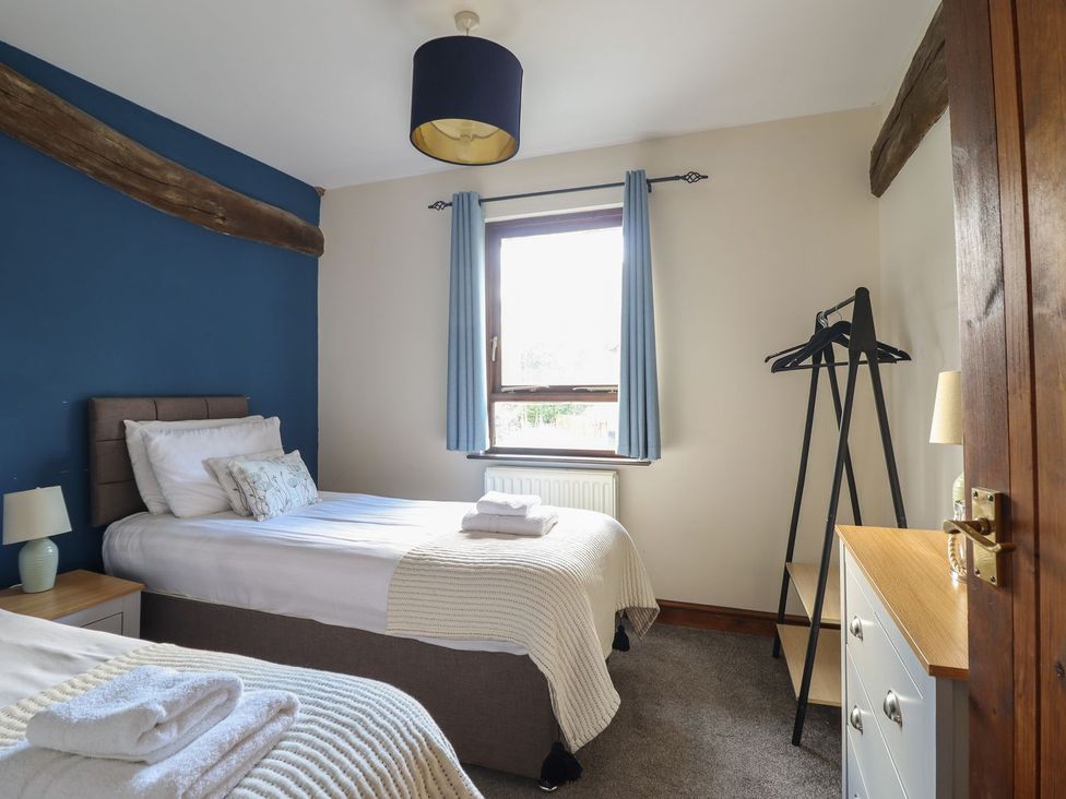 A bedroom with two beds and a window at Idris Barn in Dolgellau