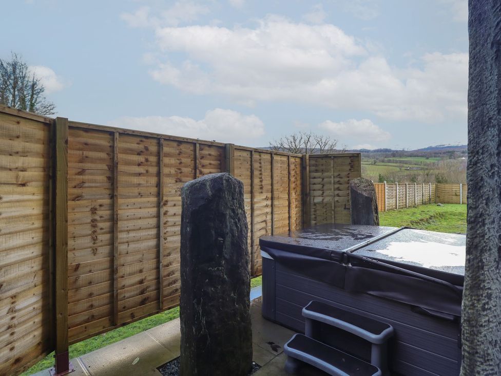 An outdoor space featuring a hot tub and wooden fencing at Idris Barn Dolgellau