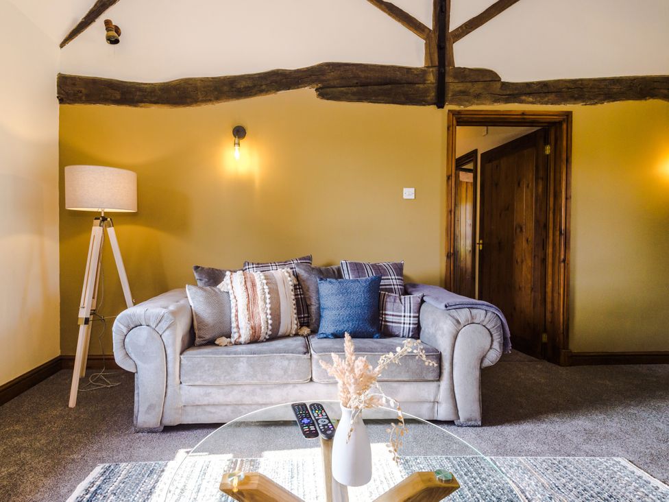 A living room with a sofa and a lamp at Idris Barn in Dolgellau