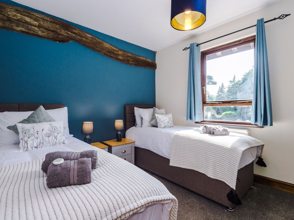 A bedroom with two beds and a window at Idris Barn Dolgellau