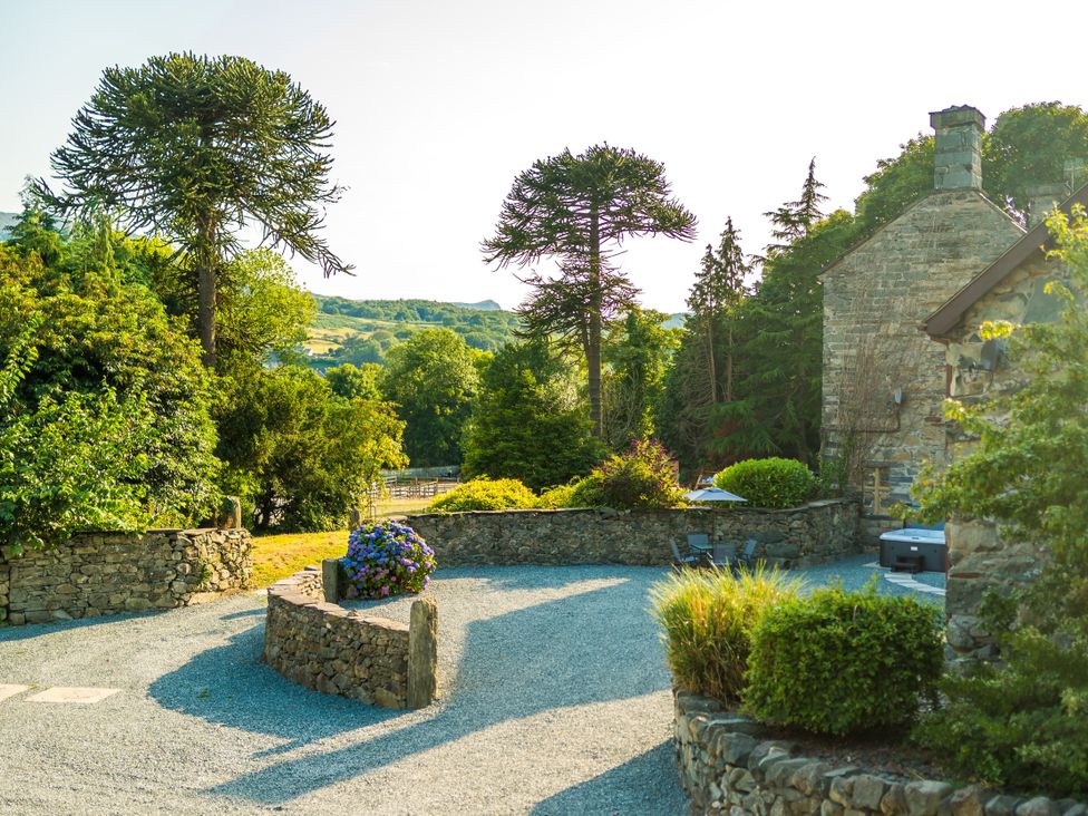 A garden with stone walls and trees at Idris Barn in Dolgellau