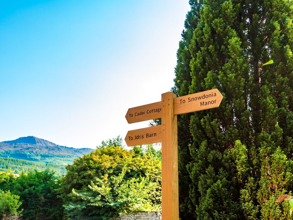 A signpost directing to Cader Cottage, Snowdonia Manor, and Idris Barn in Dolgellau