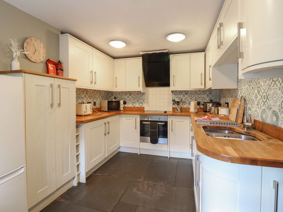 A kitchen with cabinets and appliances at Cader Cottage in Dolgellau