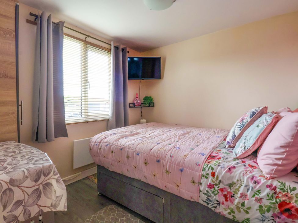 A bedroom with a bed and television at Chalet 231 in Bridlington