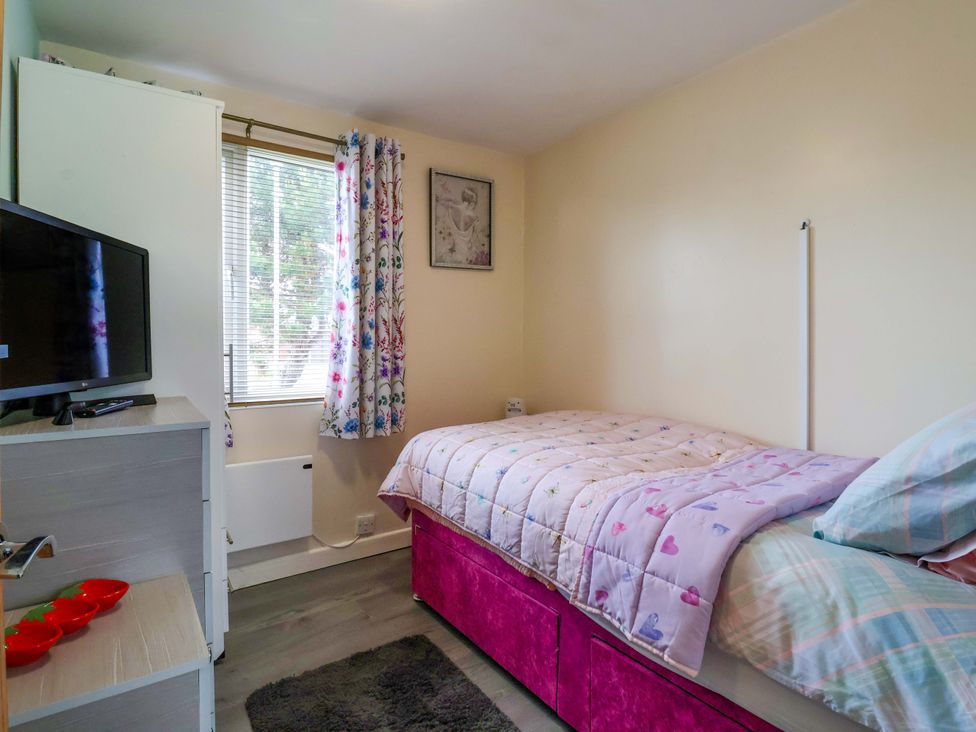 A bedroom with a bed and television at Chalet 231 in Bridlington