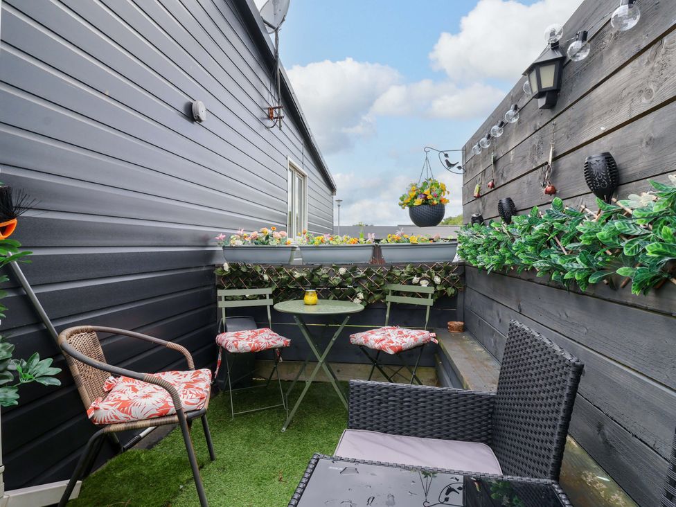 A balcony with seating and plants at Chalet 231 in Bridlington