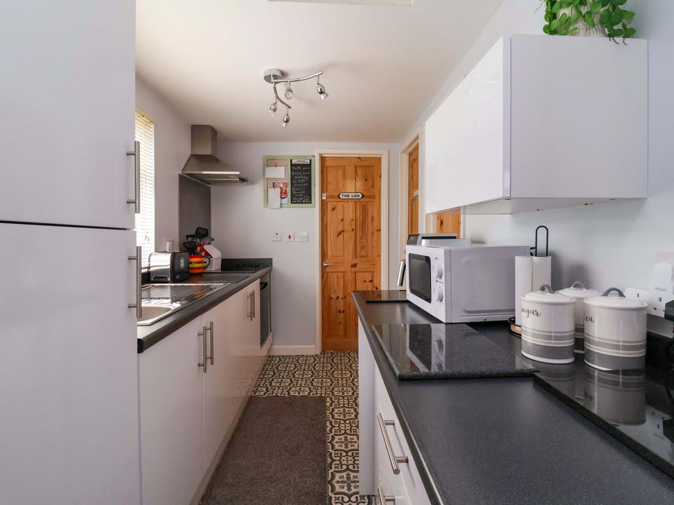 A kitchen with cabinets and a microwave at Sandbay in Bridlington
