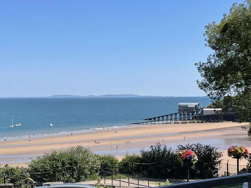 A beach view with a pier and boats at 10 Croft Court Tenby