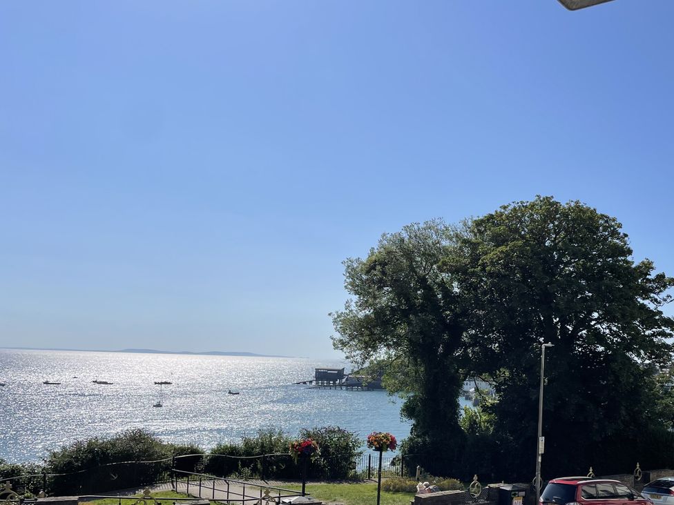 A view of the sea with boats and trees at 10 Croft Court in Tenby
