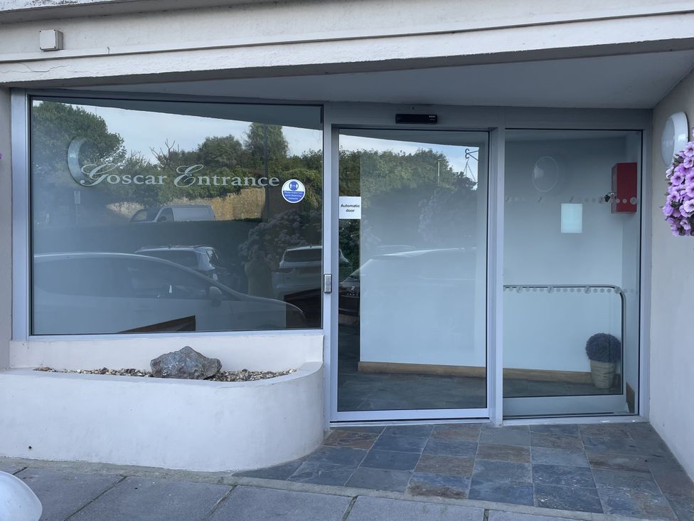 An entrance with automatic door and sign at 10 Croft Court in Tenby