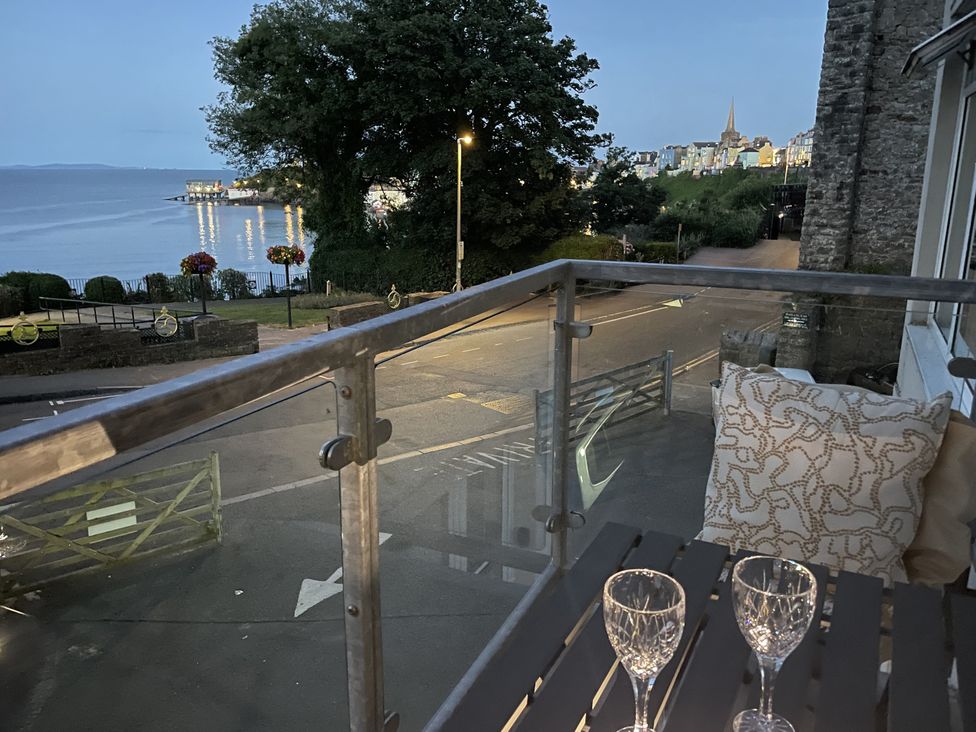 A balcony with glasses and a view of the ocean at 10 Croft Court in Tenby