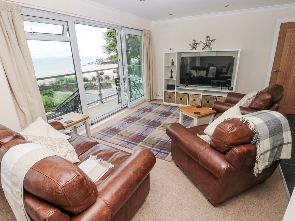 A living room with couches and a television at Lifeboat Lookout in Tenby