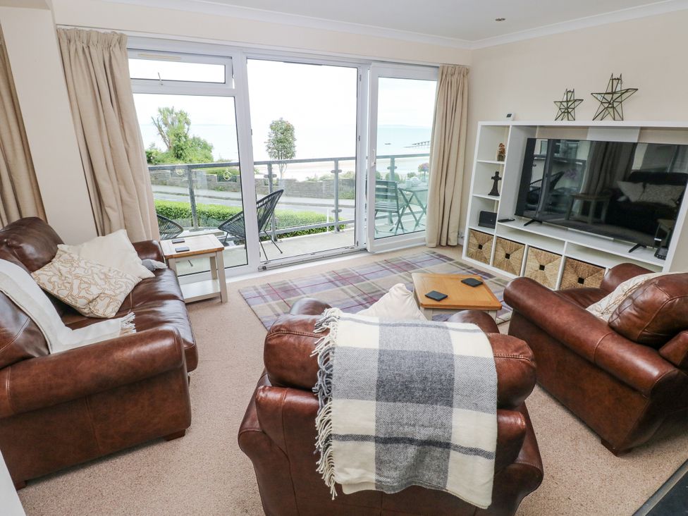 A living room with brown leather furniture and a view of the sea at Lifeboat Lookout in Tenby