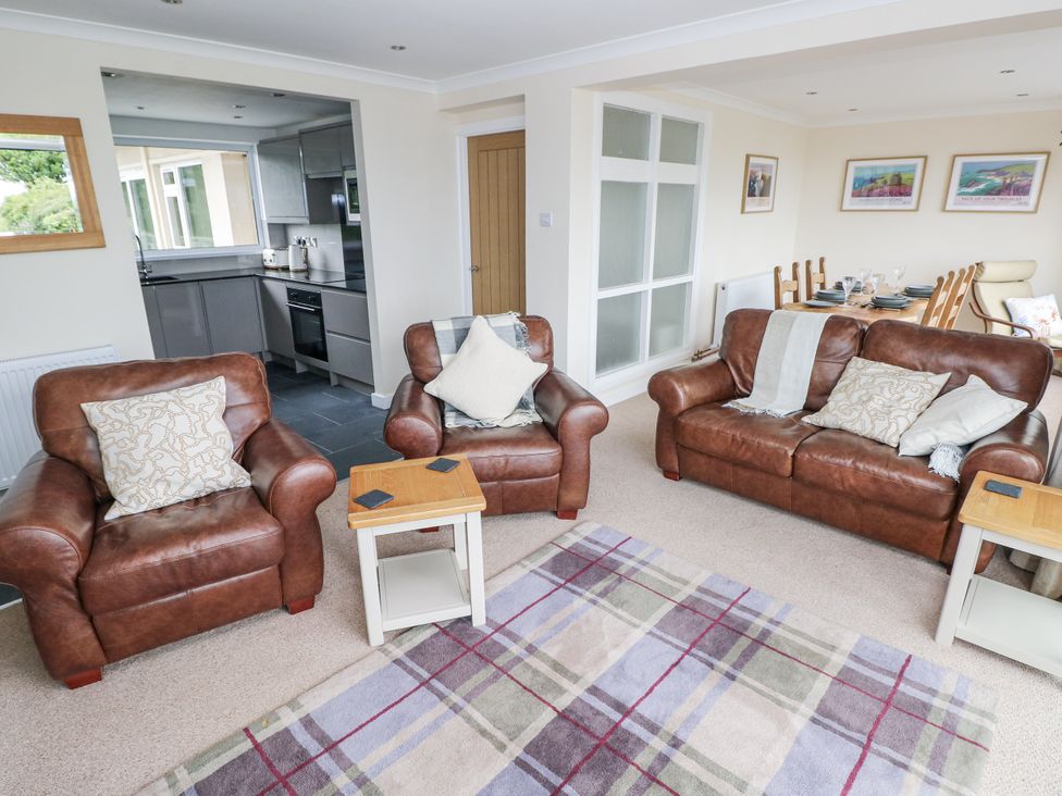 A living room with two sofas and a kitchen area at Lifeboat Lookout in Tenby