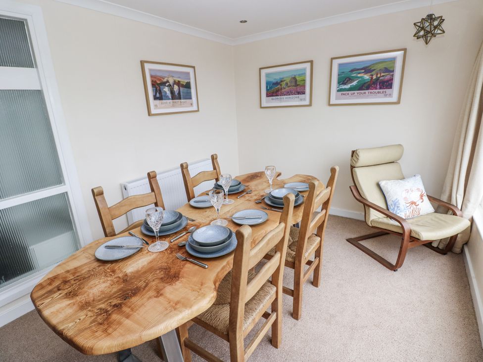A dining room with a wooden table and chairs at Lifeboat Lookout in Tenby