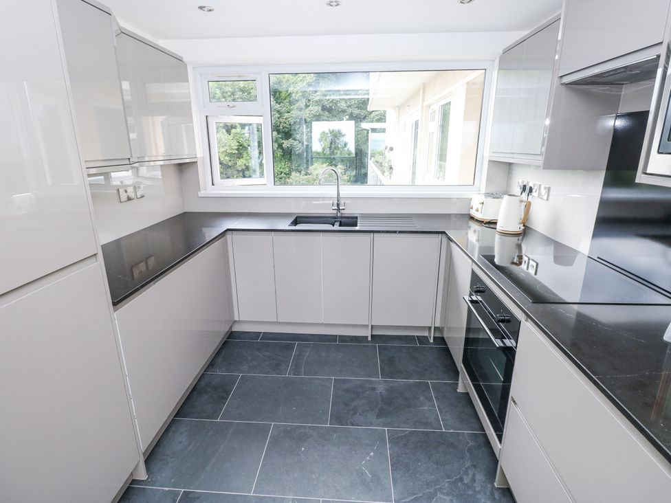 A kitchen with cabinets and a sink at Lifeboat Lookout in Tenby