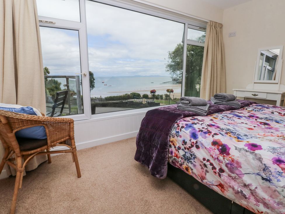A bedroom with a bed and a large window at Lifeboat Lookout in Tenby