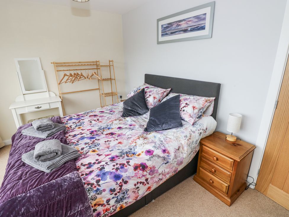 A bedroom with a bed and bedside table at Lifeboat Lookout in Tenby