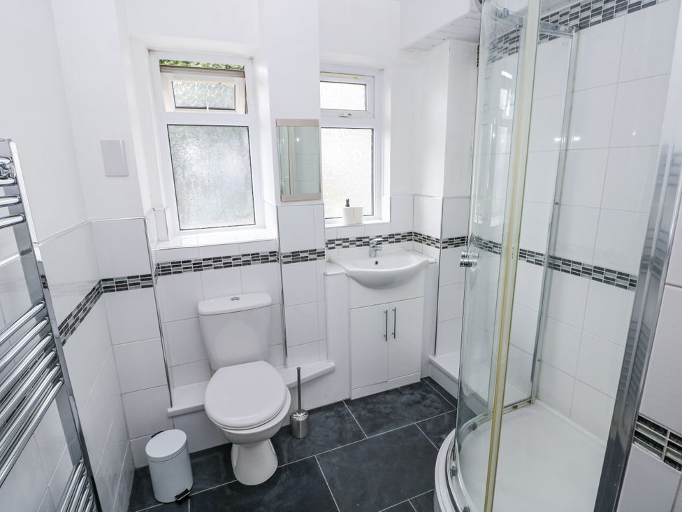 A bathroom with a shower enclosure and sink at Lifeboat Lookout in Tenby