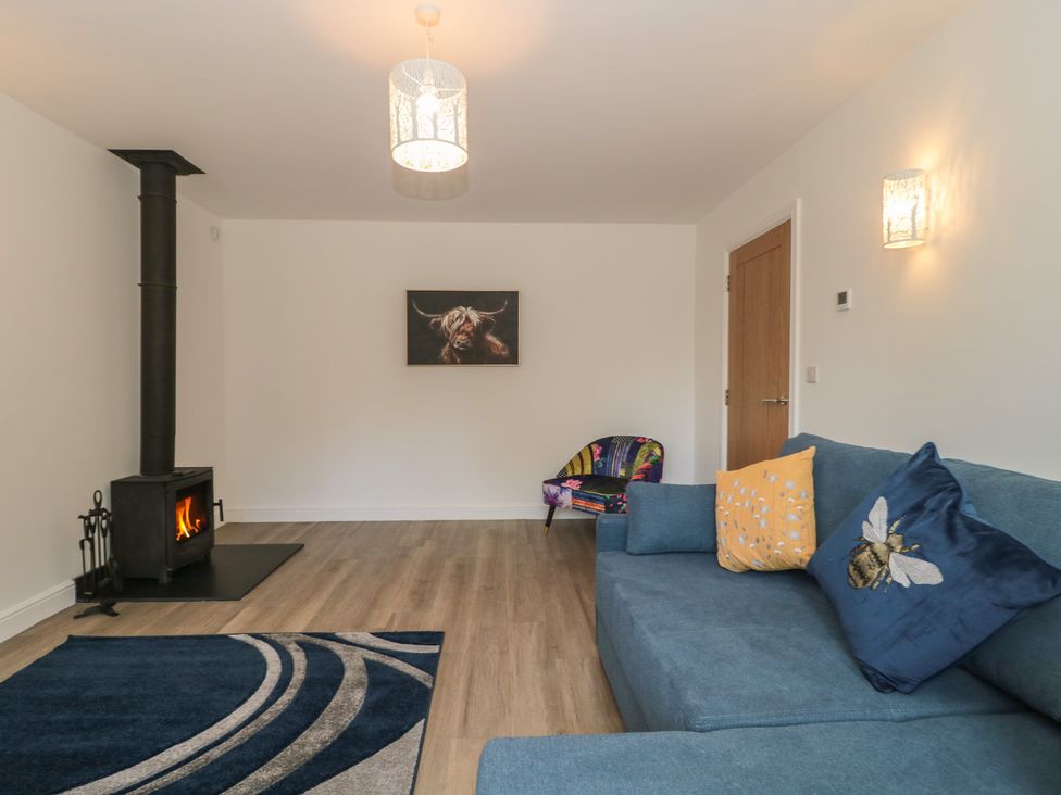 A living room with a stove and sofa at 1 The Stables in Highbridge