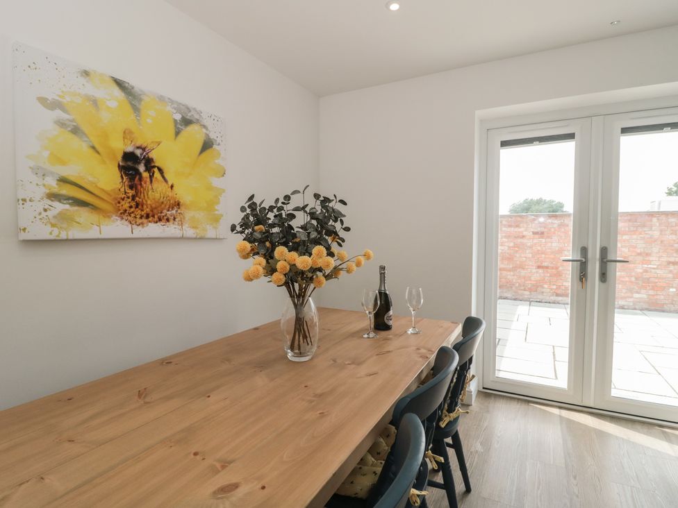 A dining room with a wooden table and chairs at 1 The Stables in Highbridge