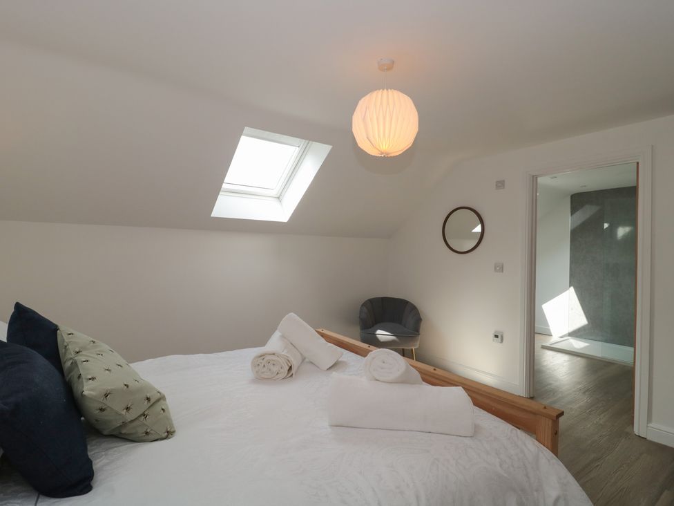 A bedroom with a bed and chair at 1 The Stables in Highbridge