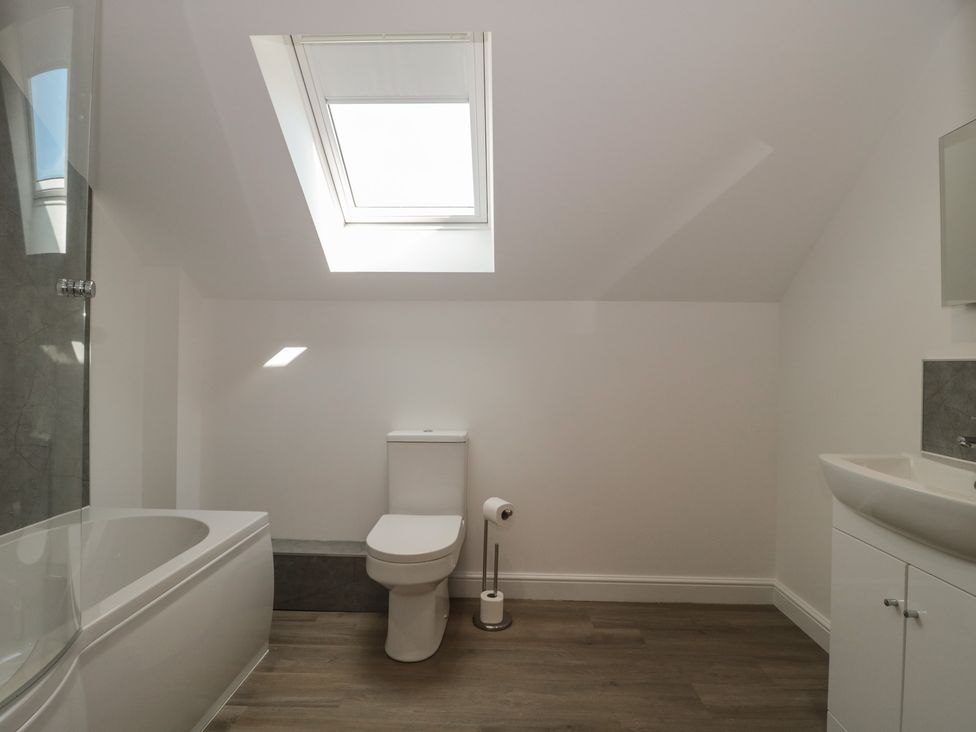 A bathroom with a bathtub, toilet, and sink at 1 The Stables Highbridge