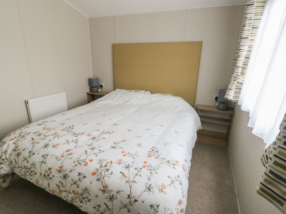 A bedroom with a bed and bedside tables at No.22