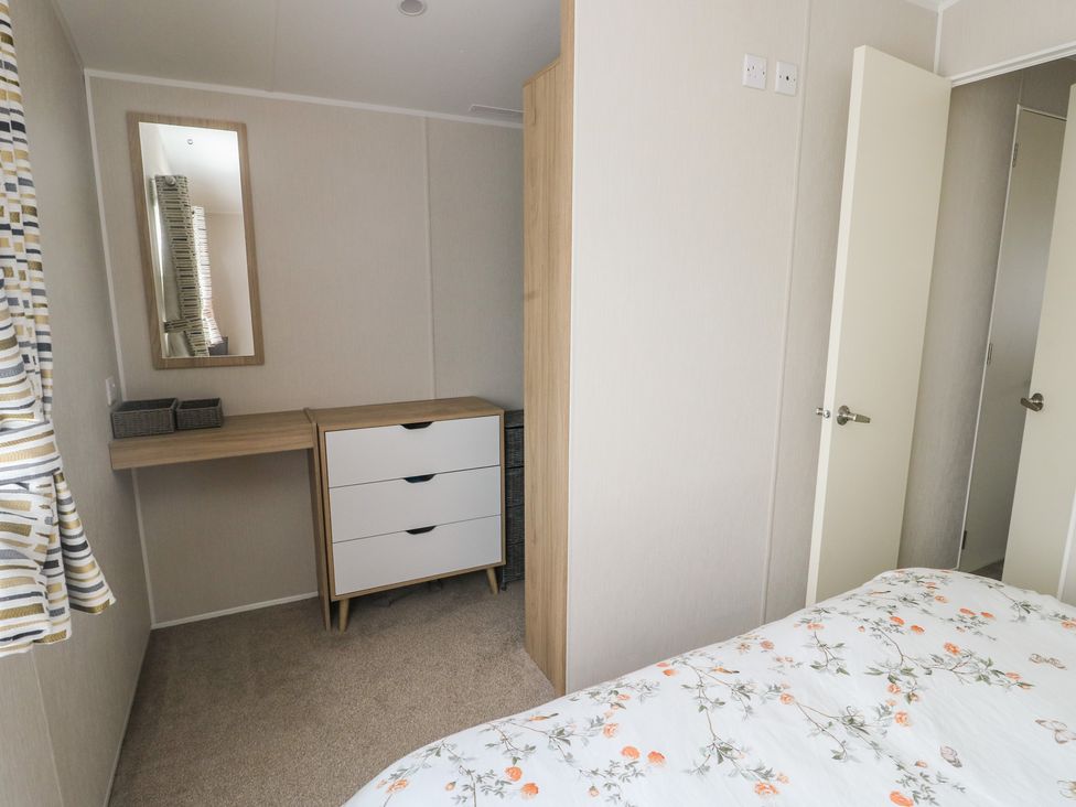 A bedroom with a dresser and mirror at No.22