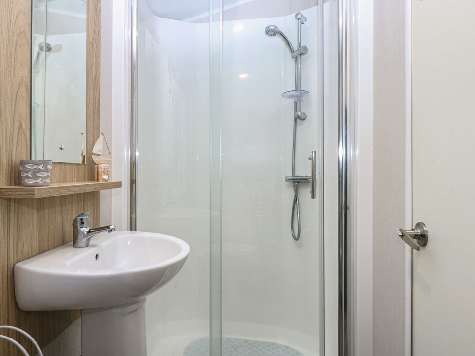 A bathroom with a shower and a basin at Woodland Way in Benllech