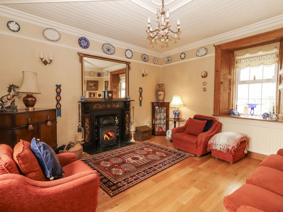 A living room with a fireplace and sofa at White Heather Cottage in Killalou