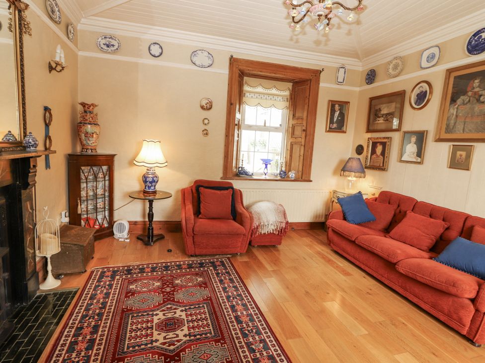 A living room with a sofa and armchair at White Heather Cottage in Killalou