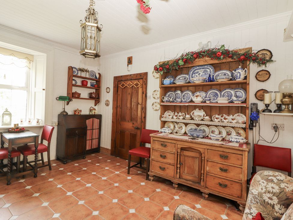 A dining room with a wooden table and chairs at White Heather Cottage in Killalou