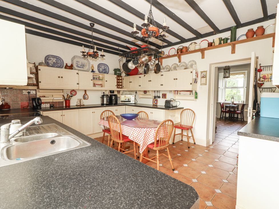 A kitchen with a table and chairs at White Heather Cottage in Killalou