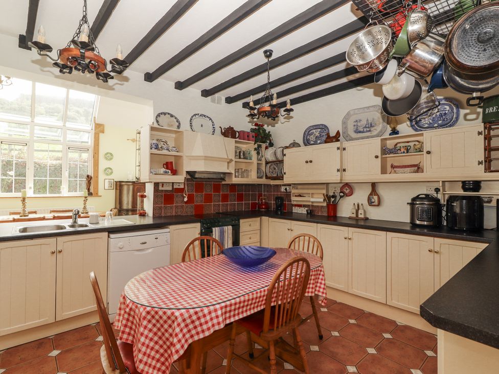 A kitchen with a table and chairs at White Heather Cottage in Killalou