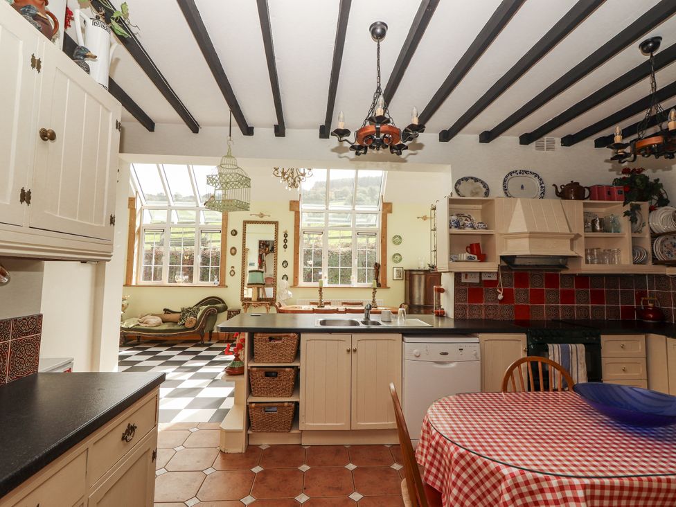 A kitchen with dining table and appliances at White Heather Cottage in Killalou