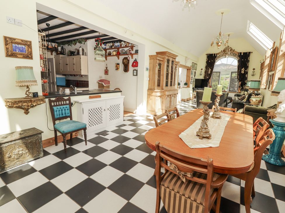 A dining room with a table and chairs at White Heather Cottage in Killalou