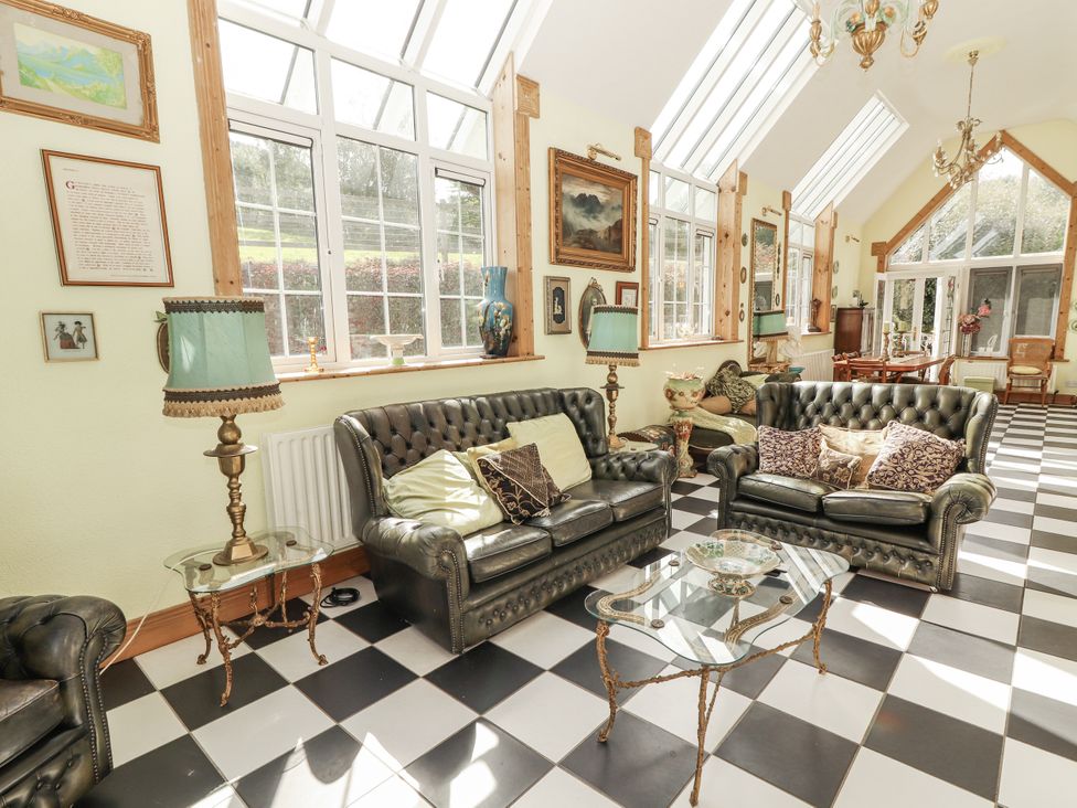 A living room with sofas and a table at White Heather Cottage in Killalou