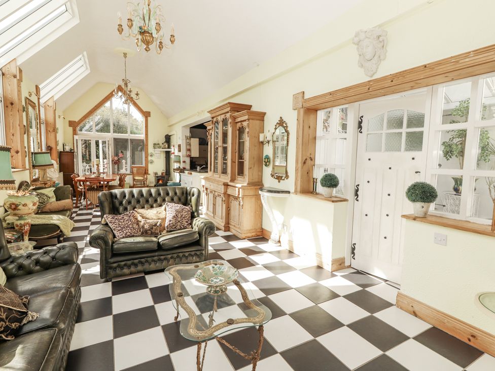 A living room with a sofa and dining area at White Heather Cottage in Killalou